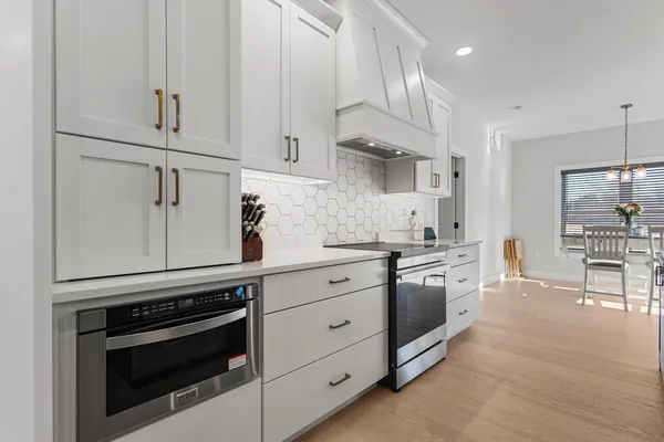 a kitchen with stainless steel appliances white cabinets and a stove a oven