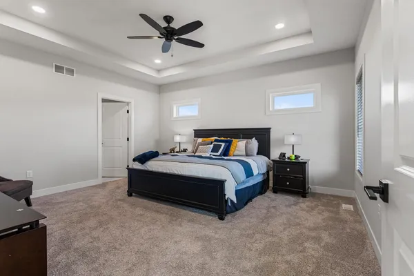 a spacious bedroom with a bed and a ceiling fan