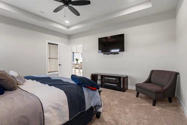 a bedroom with a bed a flat screen tv and a couch