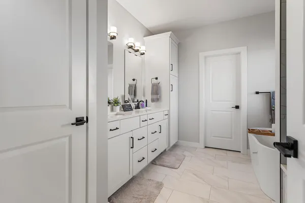 a spacious bathroom with a double vanity sink a mirror a bathtub and shower