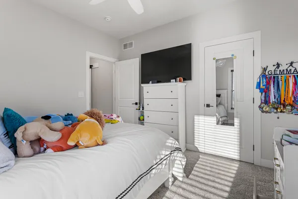 a bedroom with a bed dresser and flat screen tv