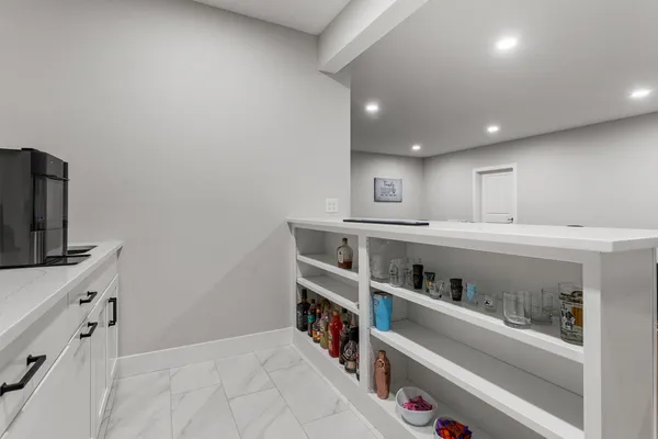 a kitchen with white cabinets a sink and a potted plant