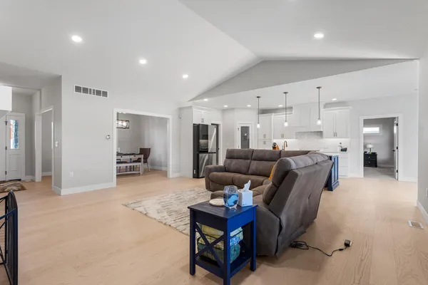 a living room with furniture and a wooden floor