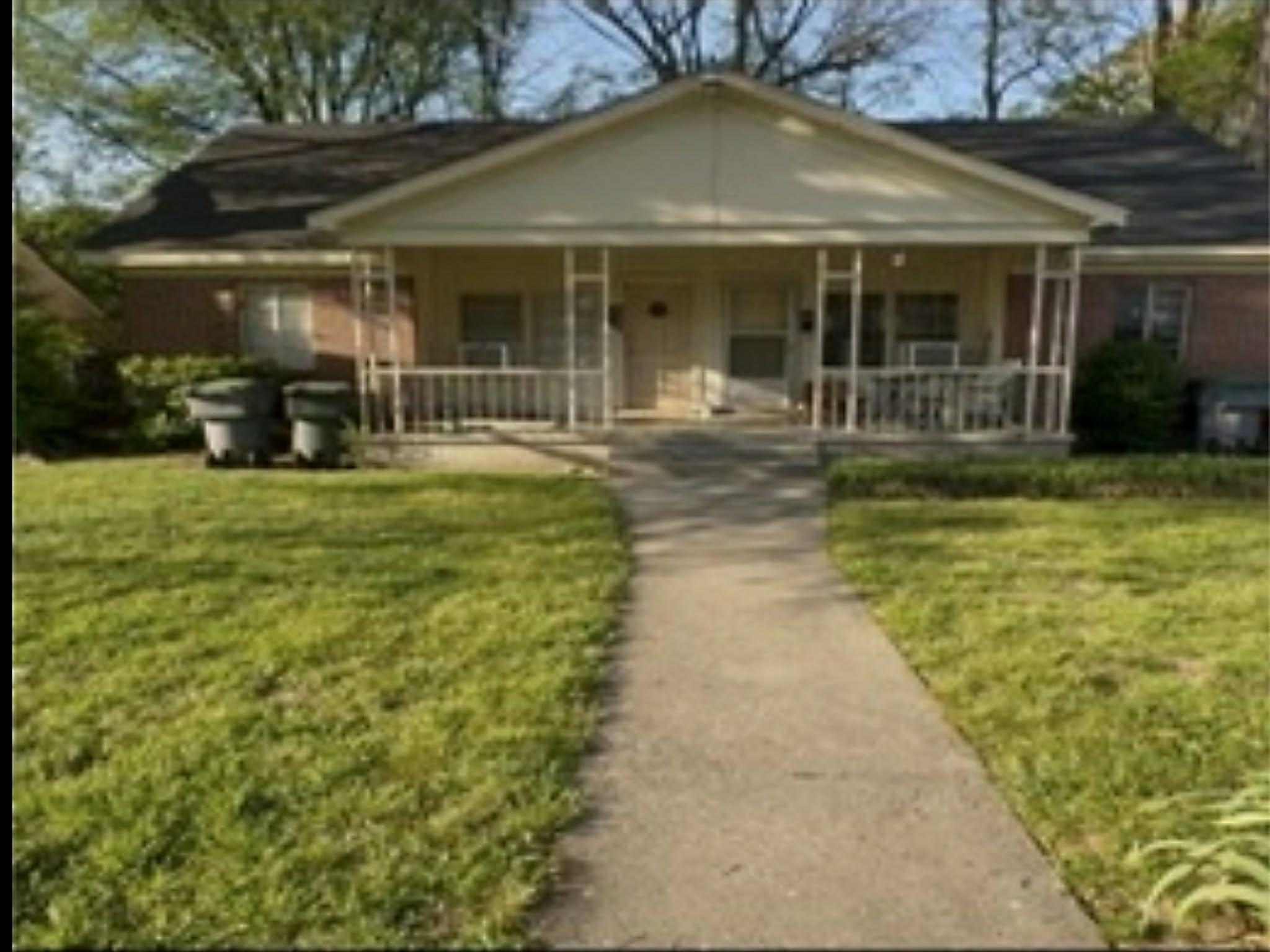 2288 Monroe Avenue Memphis, TN 38104 - Photo 1 of 3 a view of a brick house with a yard and plants