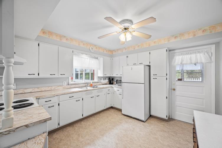 6438 Wampum Mt Air Road Wampum, PA 16157 - Photo 12 of 42 a kitchen with white cabinets and white appliances