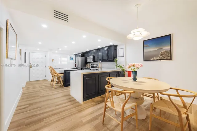 a kitchen with stainless steel appliances kitchen island granite countertop a sink and a refrigerator