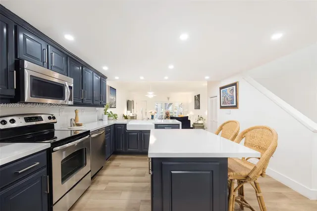 a kitchen with a sink a stove and chairs
