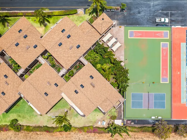 an aerial view of residential houses with outdoor space and trees