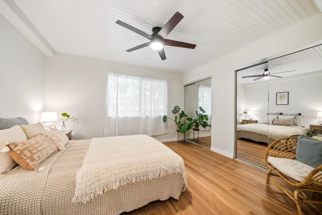 a bedroom with a bed and wooden floor