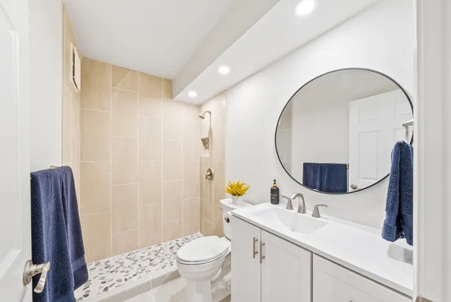 a bathroom with a sink a toilet and a mirror