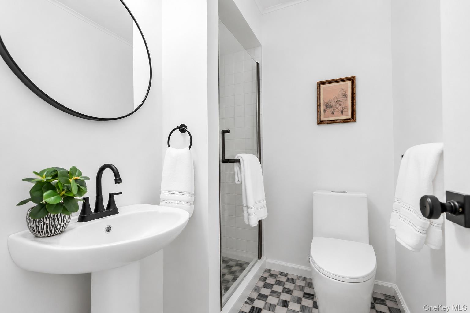 275 Pinewood Road Cutchogue, NY 11935 - Photo 21 of 45 Pedestal sink with matte black faucet, checkered tile flooring, glass-enclosed shower, white toilet, and matte black door hardware