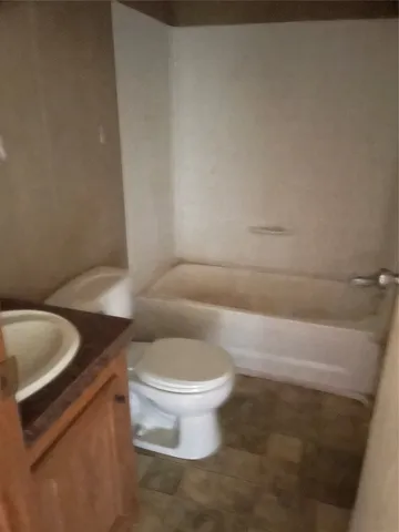 a bathroom with a granite countertop toilet and a sink