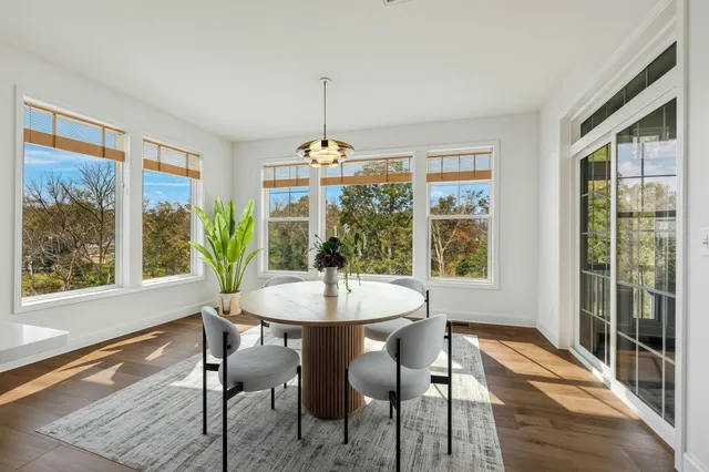 a kitchen with granite countertop a stove a sink and white cabinets with wooden floors