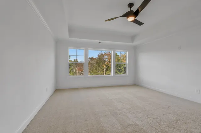 an empty room with a ceiling fan and window