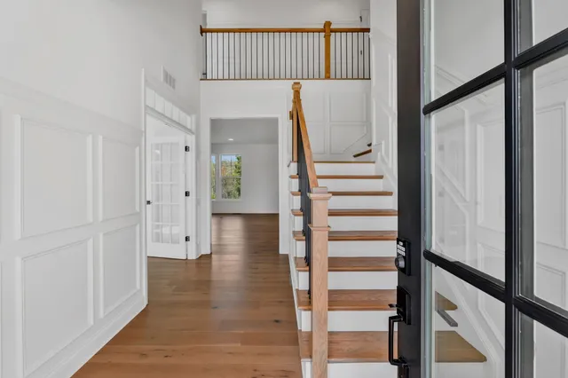 a view of a hallway with wooden floor and staircase