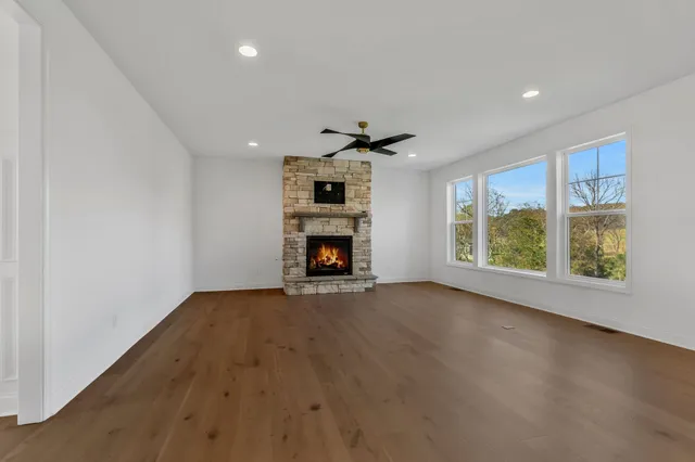 a view of an empty room with a window and fireplace