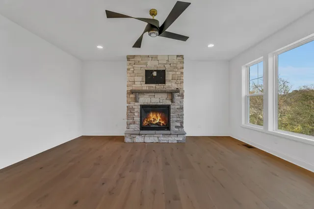 a view of an empty room with a fireplace and a window