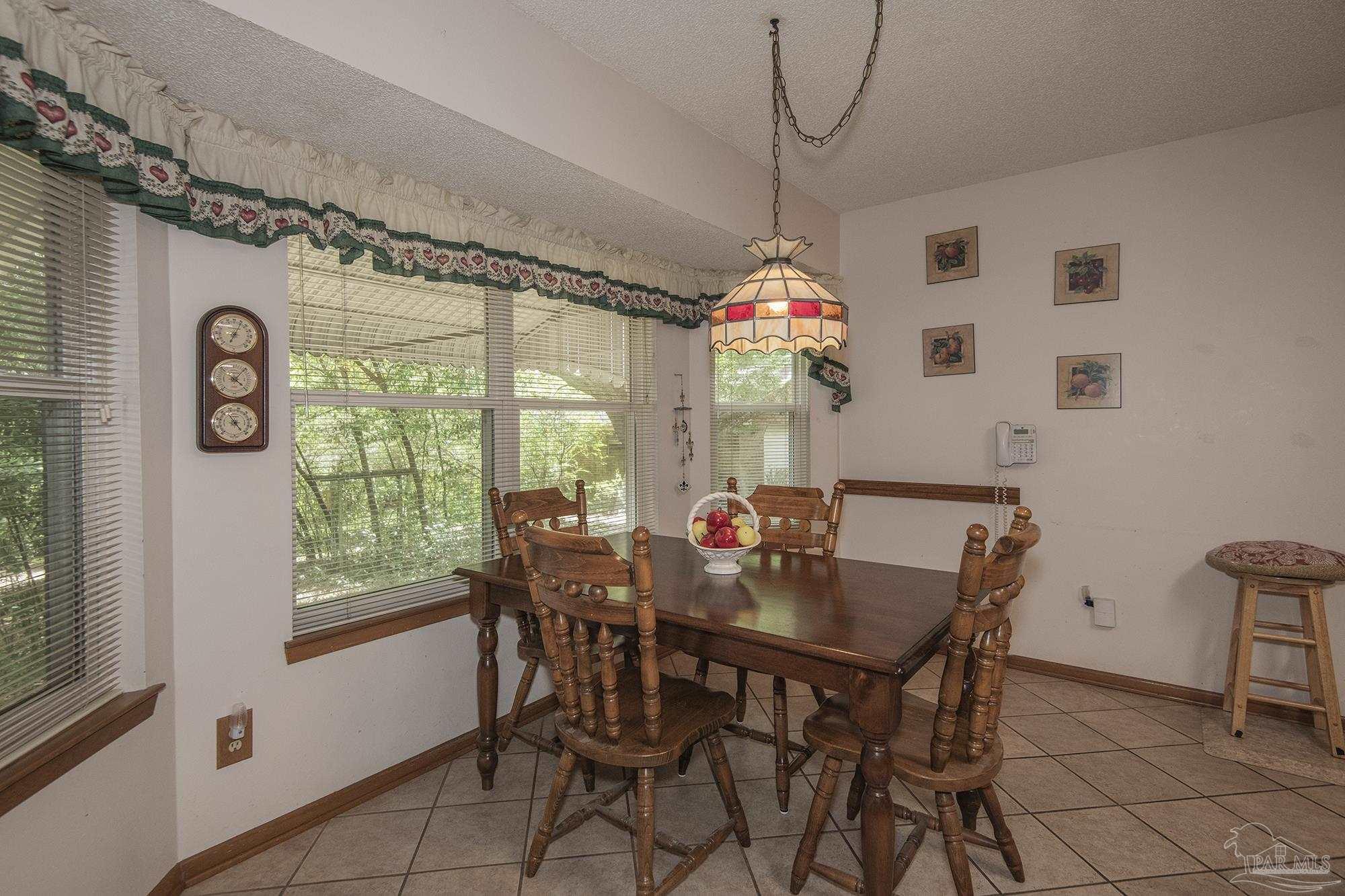 1210 Goldenrod Road Cantonment, FL 32533 - Photo 8 of 50 a view of a dining room with furniture window and outside view