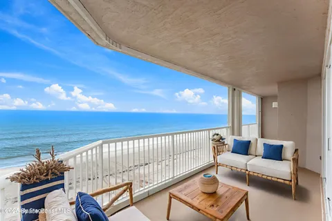 a front view of multi story residential apartment building with yard and outdoor seating