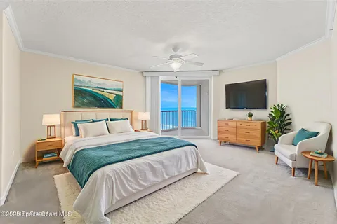 a spacious bedroom with a bed and a flat screen tv