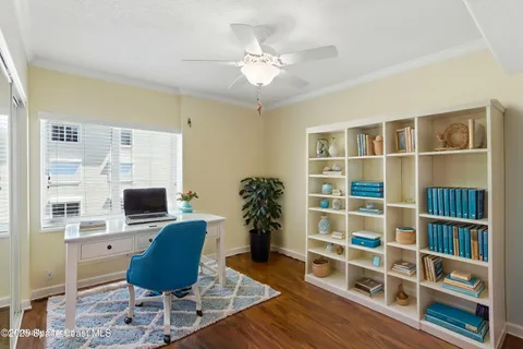 a view of a workspace with furniture and a window