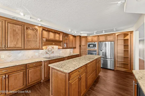 a kitchen with stainless steel appliances granite countertop a sink and wooden cabinets