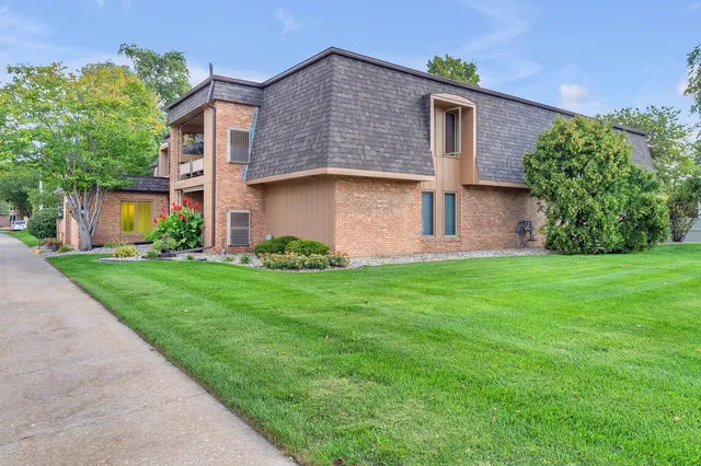 a front view of a house with a garden and plants