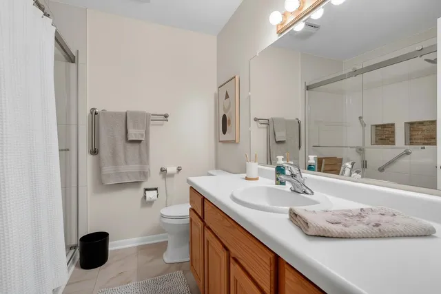 a bathroom with a sink a toilet and shower