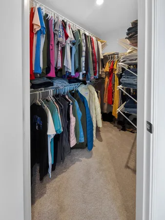 a view of walk in closet with clothes and shoes