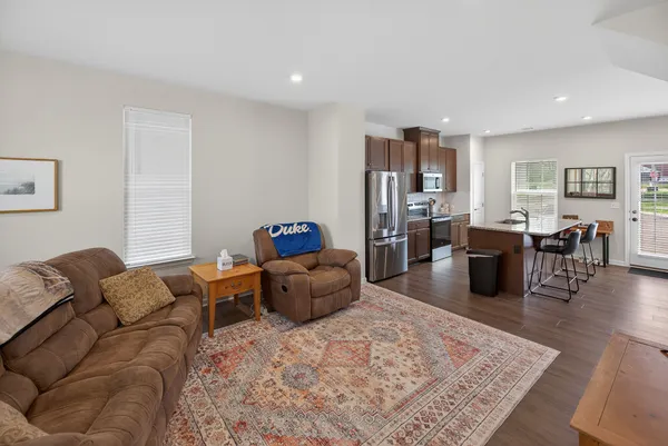 a living room with furniture kitchen view and a window