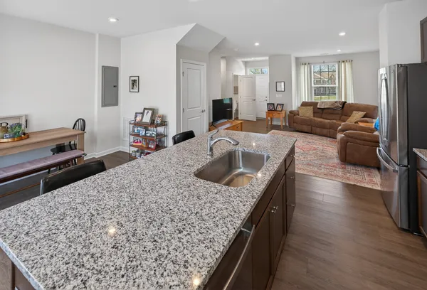 a kitchen with kitchen island granite countertop a sink stove and refrigerator