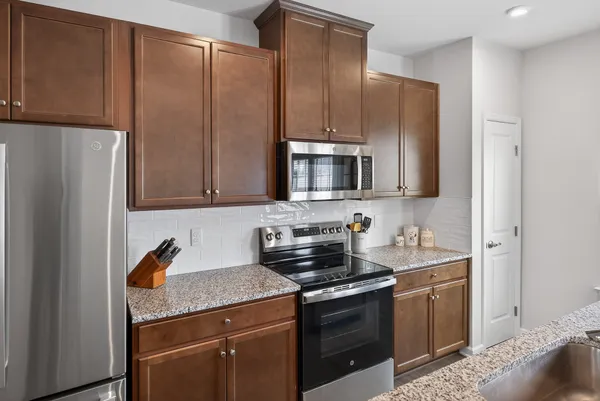 a kitchen with stainless steel appliances granite countertop a refrigerator stove and sink
