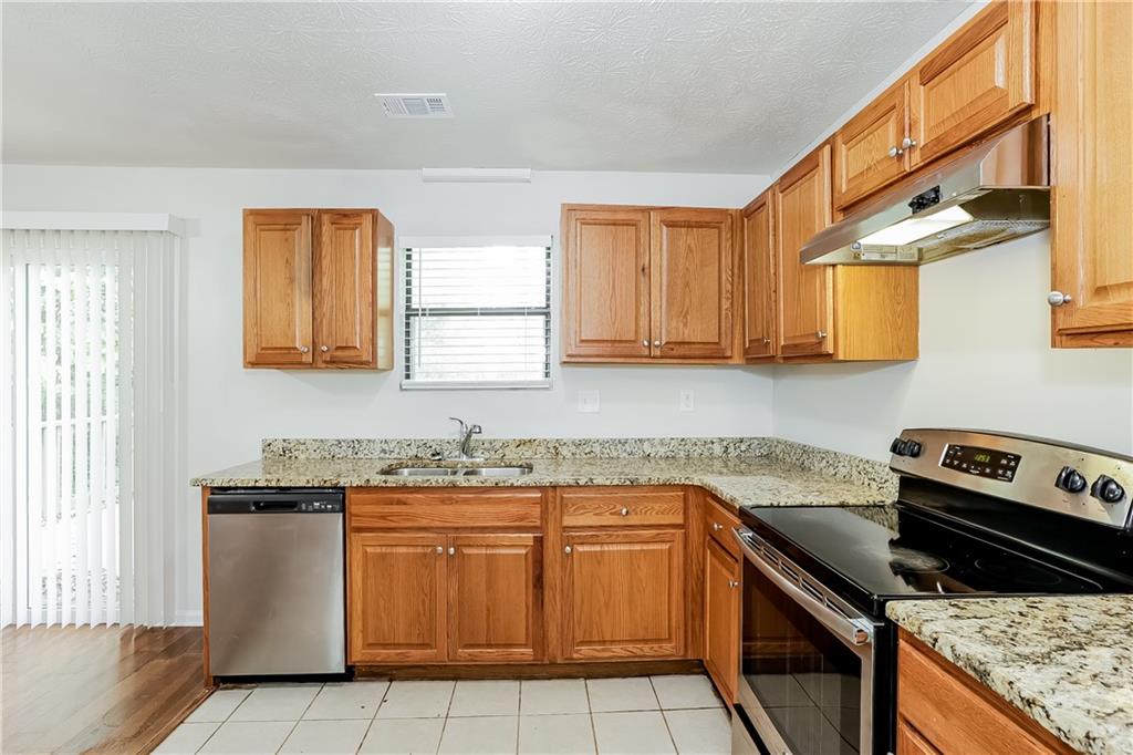 3352 Herrenhut Road Lithonia, GA 30038 - Photo 9 of 27 a kitchen with a stove a sink and a microwave