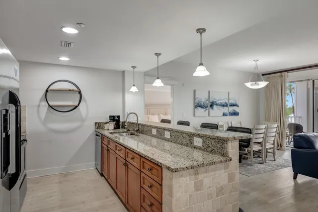 a kitchen with granite countertop cabinets a sink a window and stainless steel appliances