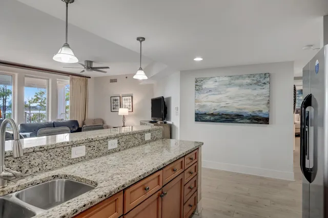 a view of a kitchen with stainless steel appliances granite countertop a sink and a refrigerator