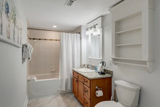 a bathroom with a granite countertop sink toilet and shower