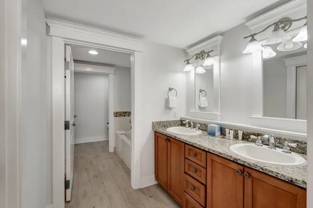 a bathroom with a granite countertop double vanity sink mirror and double