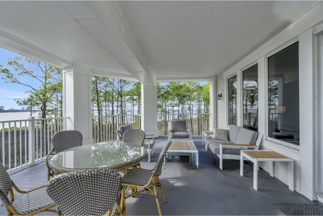 a dining room with furniture large windows and wooden floor