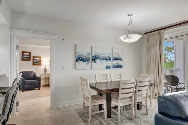 a view of a dining room and livingroom with furniture wooden floor a chandelier