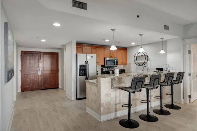 an open kitchen with refrigerator and chairs