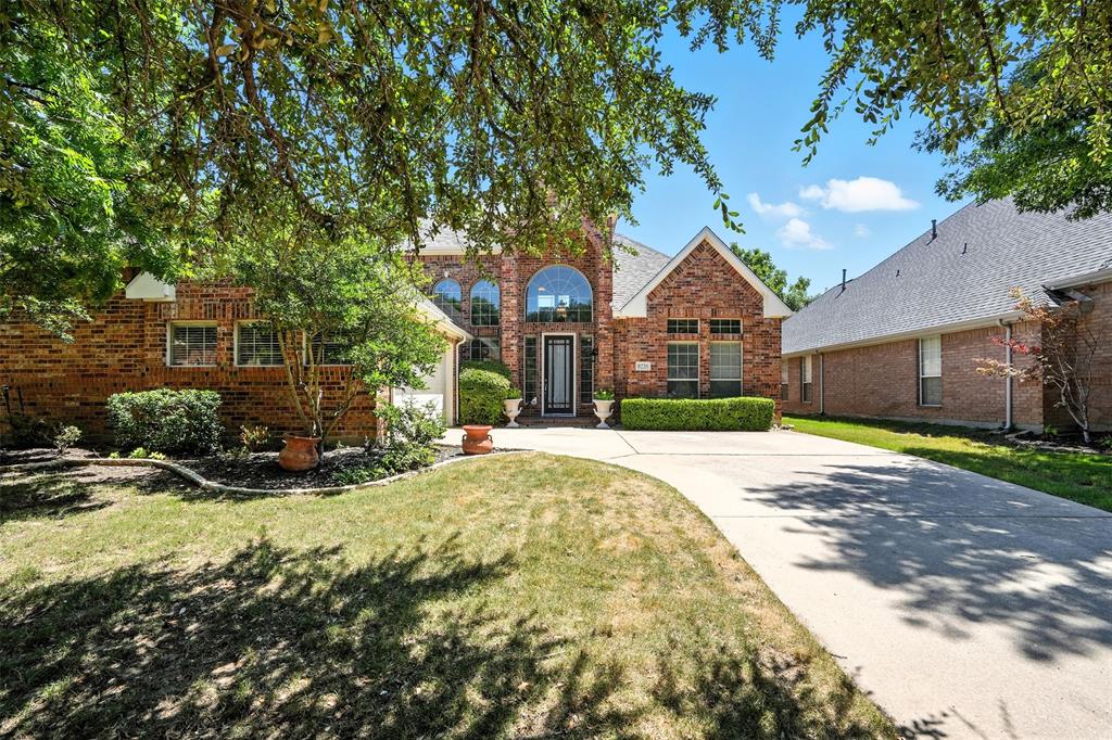 8220 Holliday Road Lantana, TX 76226 - Photo 3 of 40 Brick facade residence with arched window accents, a covered entry, and an attached garage