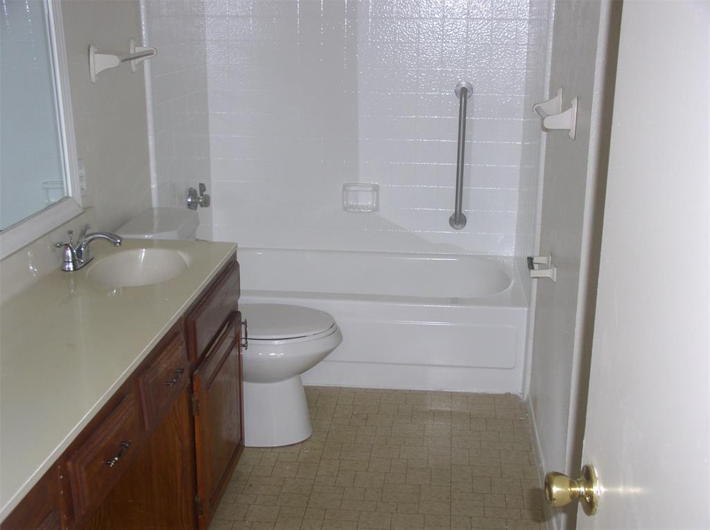 7210 Pineberry Road Dallas, TX 75249 - Photo 5 of 8 a bathroom with a sink a toilet and shower
