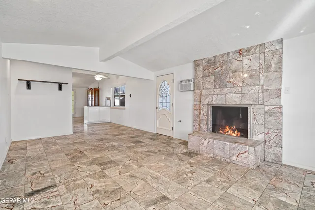 a view of empty room with a fireplace and window