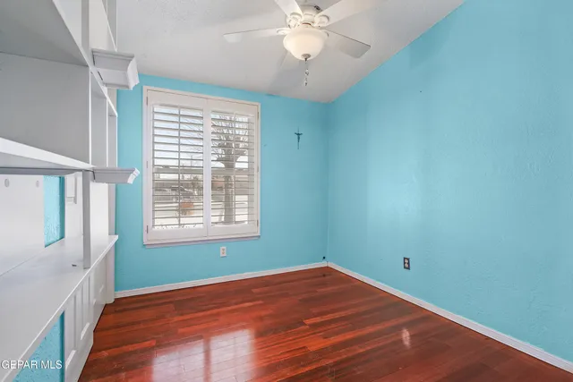 a view of empty room with wooden floor and cabinet