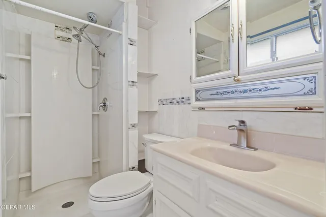 a view of an room with large windows and a ceiling fan