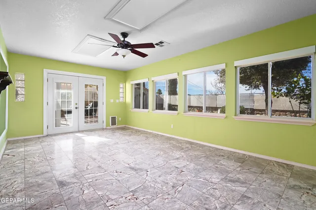 a view of a livingroom with a chandelier fan and windows