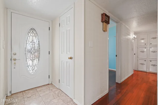 a view of a hallway with wooden floor and a bathroom