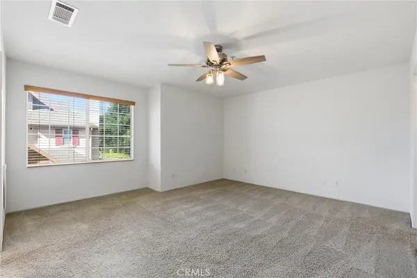 an empty room with windows and fan