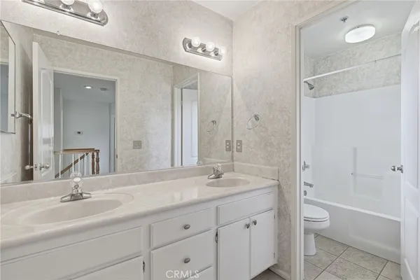 a bathroom with a granite countertop sink toilet a shower and a mirror