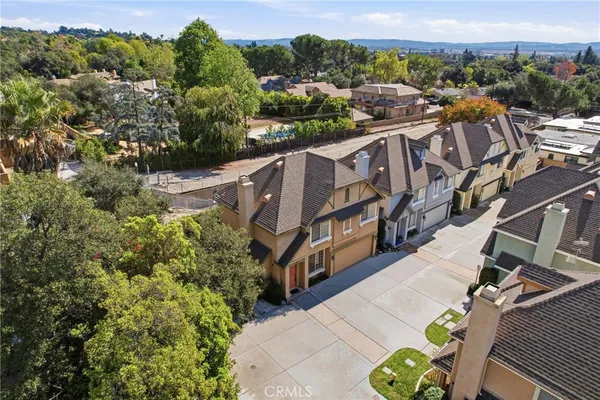 an aerial view of residential houses with outdoor space and trees